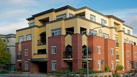 apartment building with brick and yellow stucco exterior